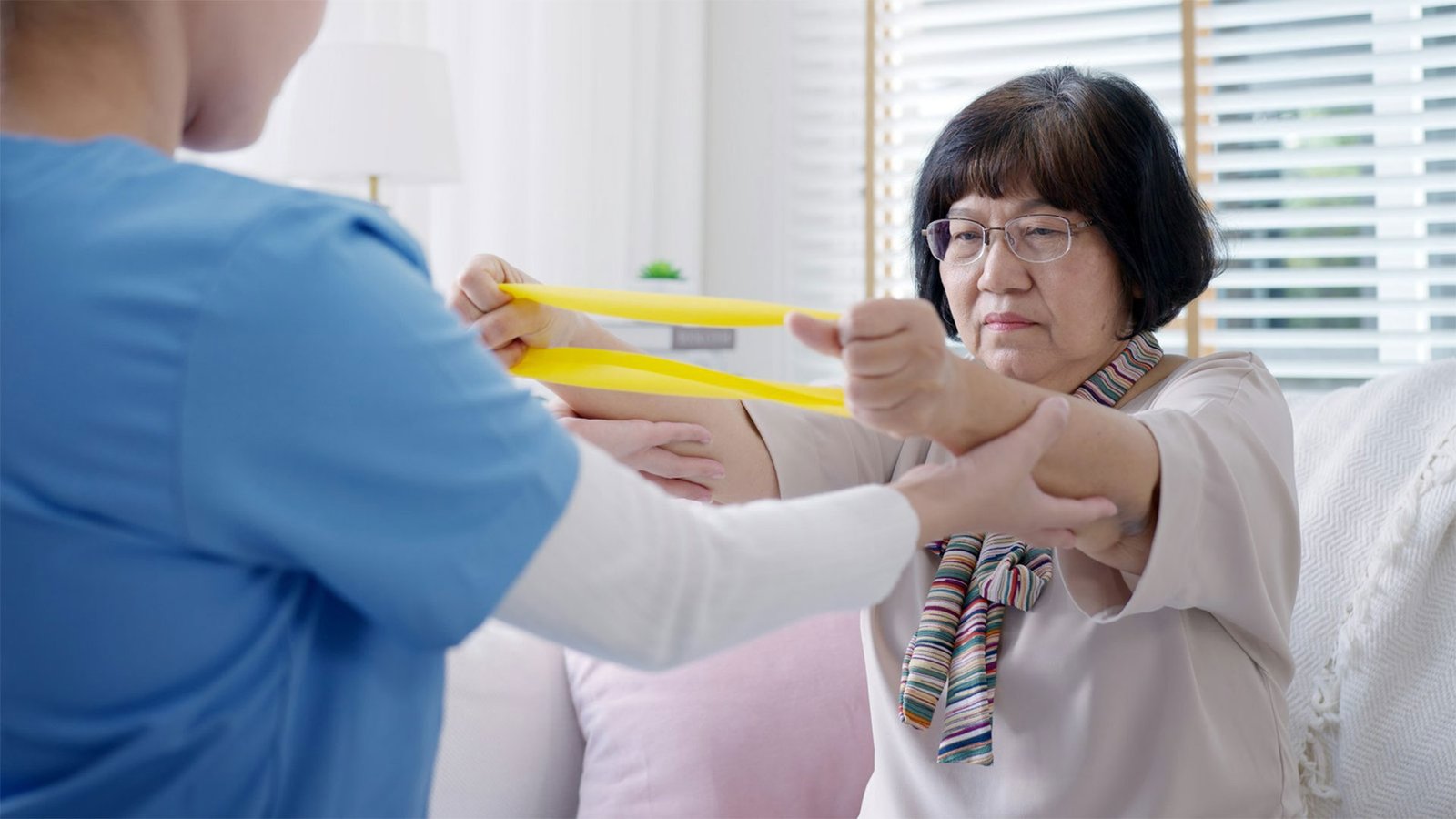 Young older senior asia citizen sit on sofa couch with in-home nursing care